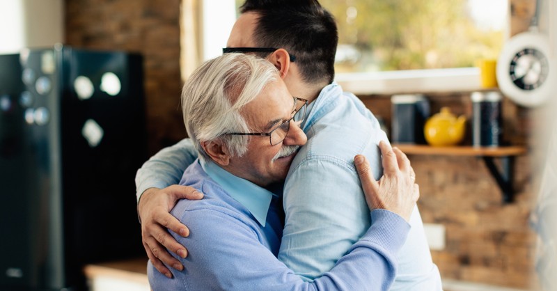 dad hugging prodigal adult son, his grace was greater hymns about grace