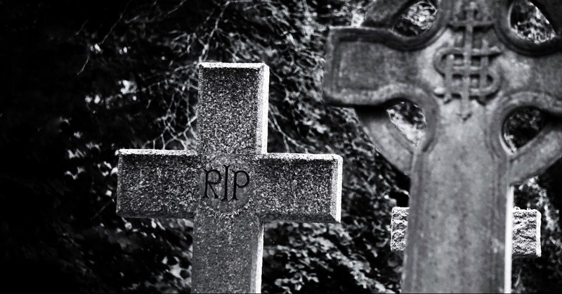 Cross headstone that reads RIP, faith of our fathers hymns about freedom