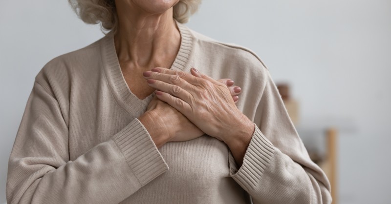 senior grandma praying with hand over heart