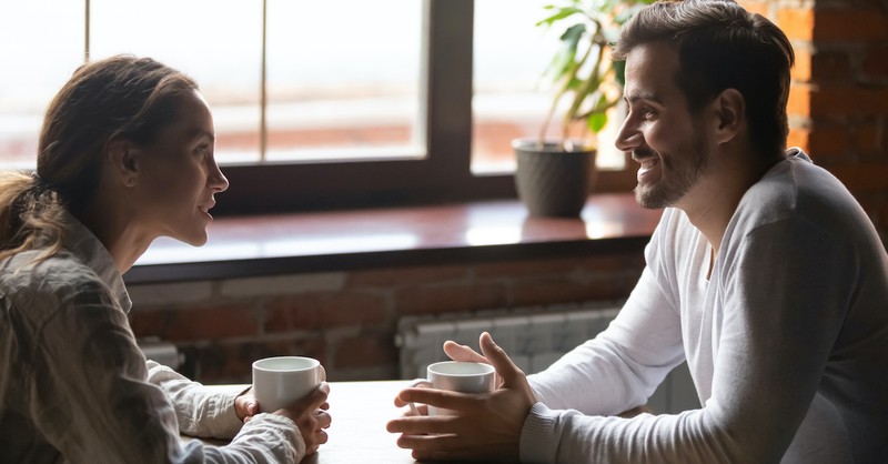couple happily talking on date at coffee shop, dating advice tips
