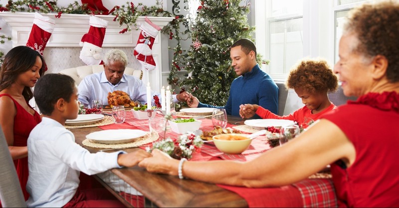 Family praying at Christmas dinner