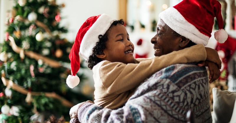 grandchild and grandparent hugging at christmas with santa hats, old fashioned christmas tips and tricks