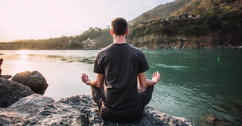 man meditating on rocks, is meditation a sin