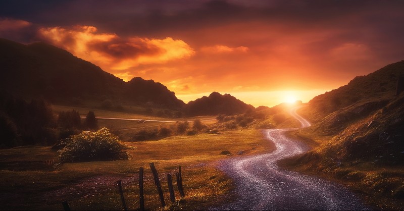 Mountain path leading towards sunrise