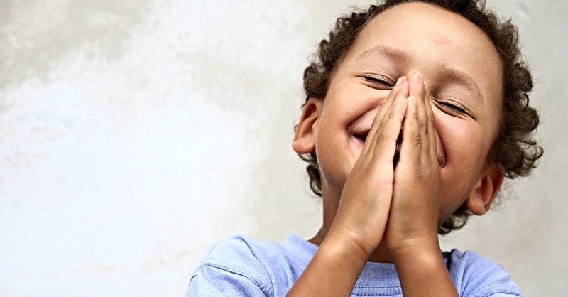 close up of happy little boy praying