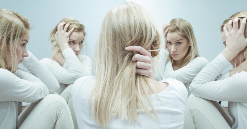 woman looking in the mirror feeling ashamed