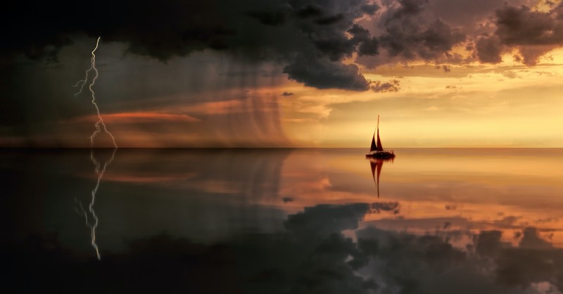 boat sailing into storm clouds over sea