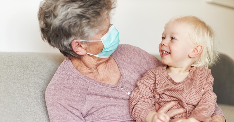 grandma wearing a mask with grandson baby