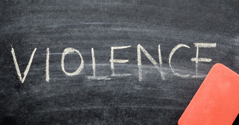 Word violence being erased on a chalkboard