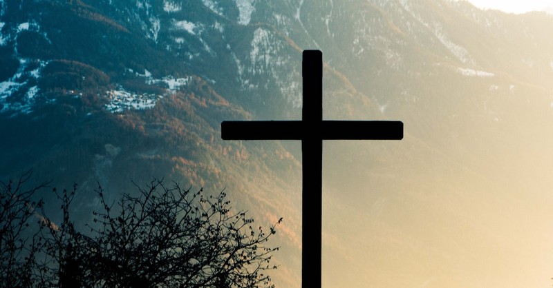 silhouette of cross in mountain landscape