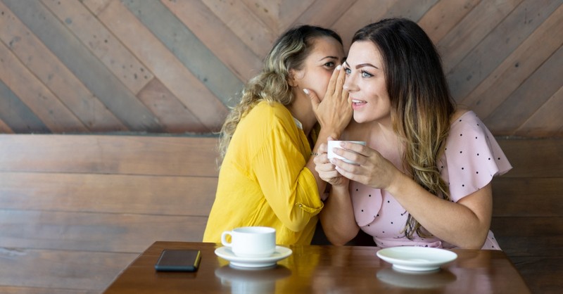 Two women gossiping over coffee