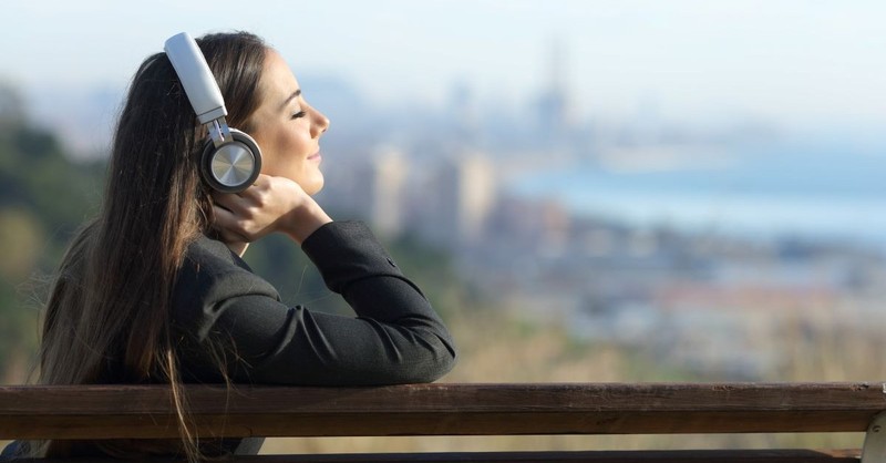 woman outside listening to headphones