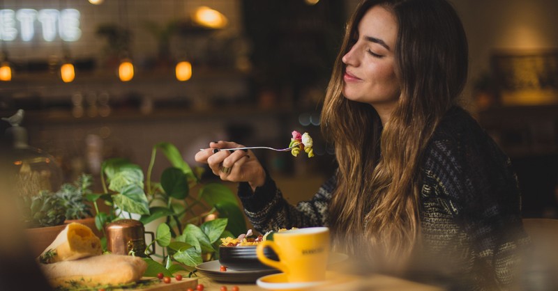 woman eating and smiling content dinner