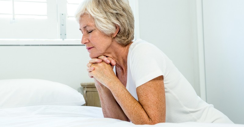 Senior woman praying before bed