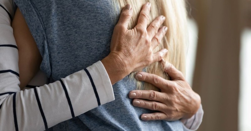 Older woman hugging a younger woman in forgiveness