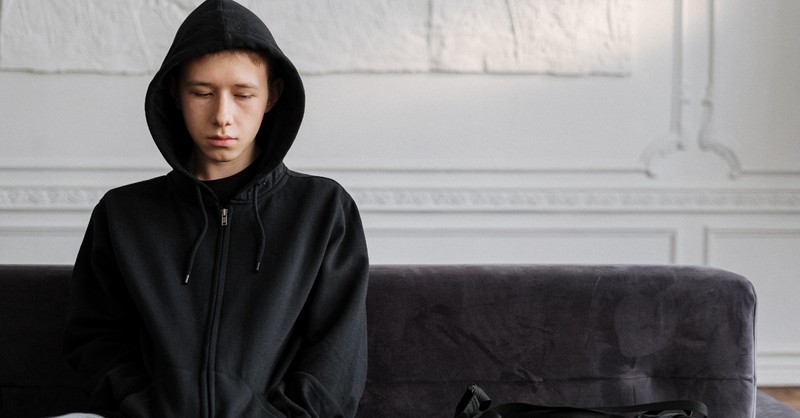 teen in hoodie looking depressed and sad