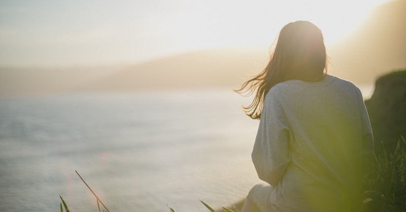 woman at water praying thinking