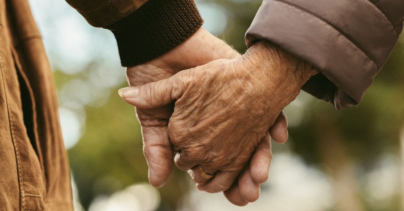 Elderly couple holding hands