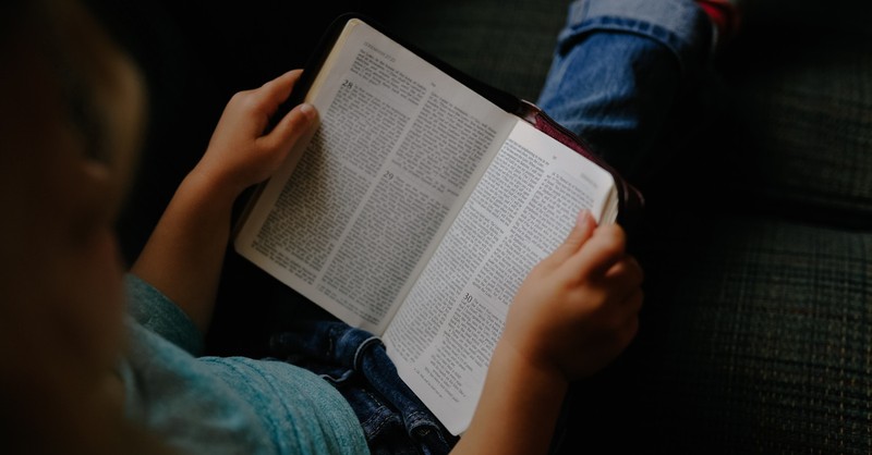 a little girl reading a Bible, Illinois school reverses course after banning girl from reading her Bible