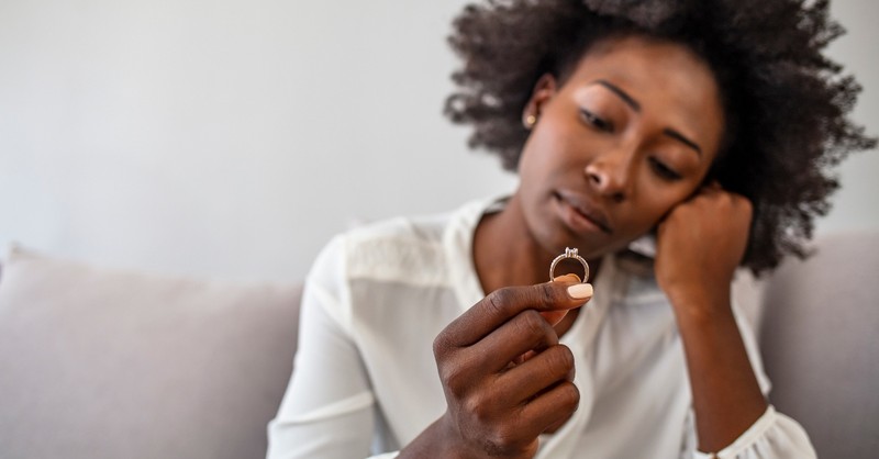 woman holding looking at engagement ring thinking, long engagement