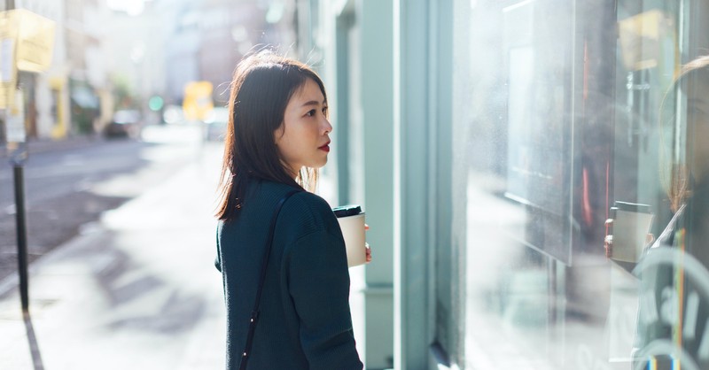 woman looking into glass store window, envy vs. jealousy