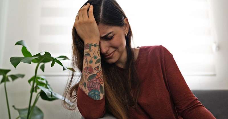 Woman crying on her couch