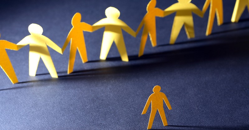 row of paper men in front of a single paper man, single person feeling left out