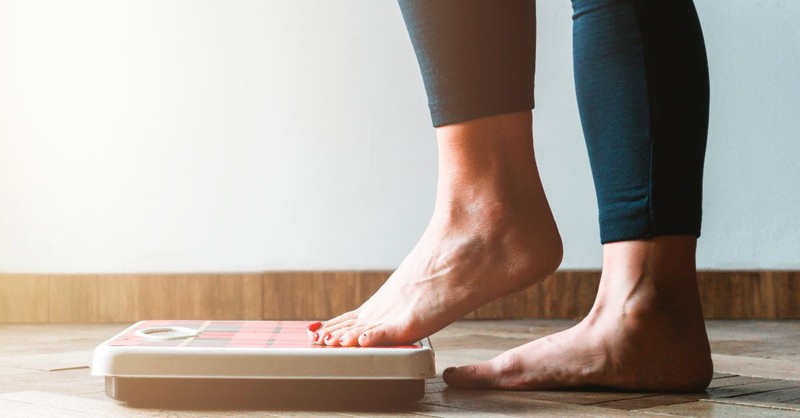 Woman stepping on a scale