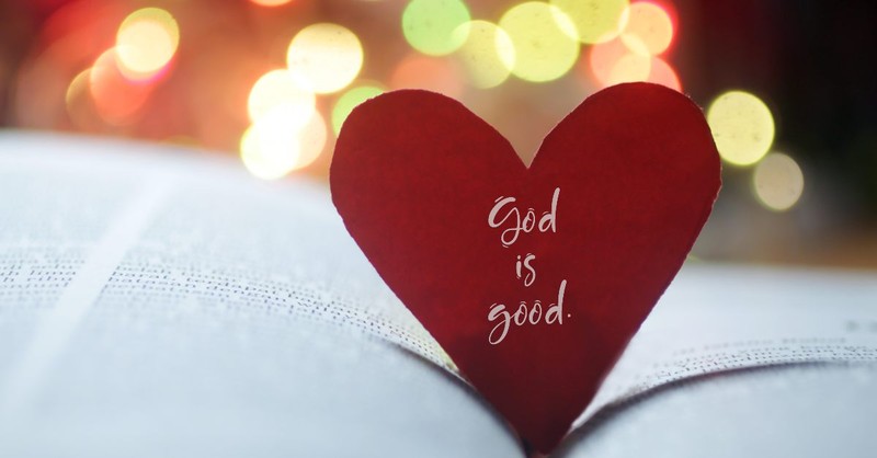 Paper heart that says God is good resting in a Bible