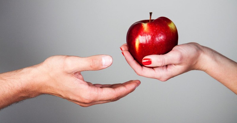 Woman giving a man an apple