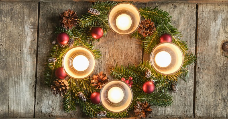 advent candles in wreath on wooden background