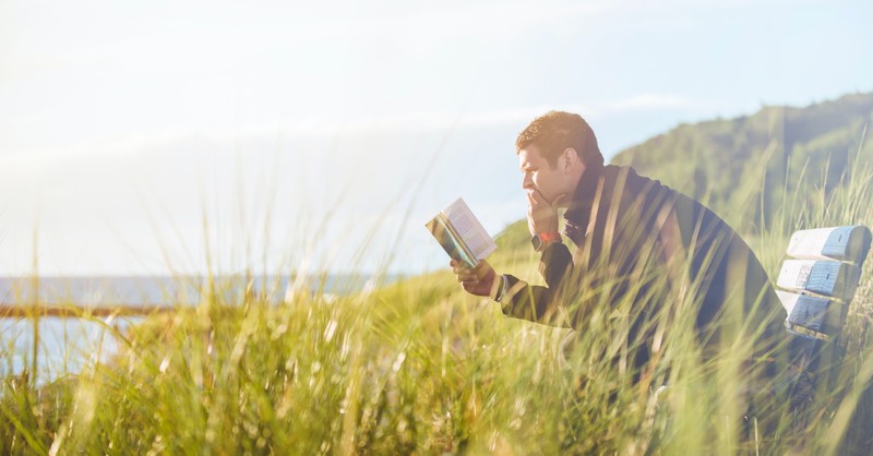 a man reading the Bible outside