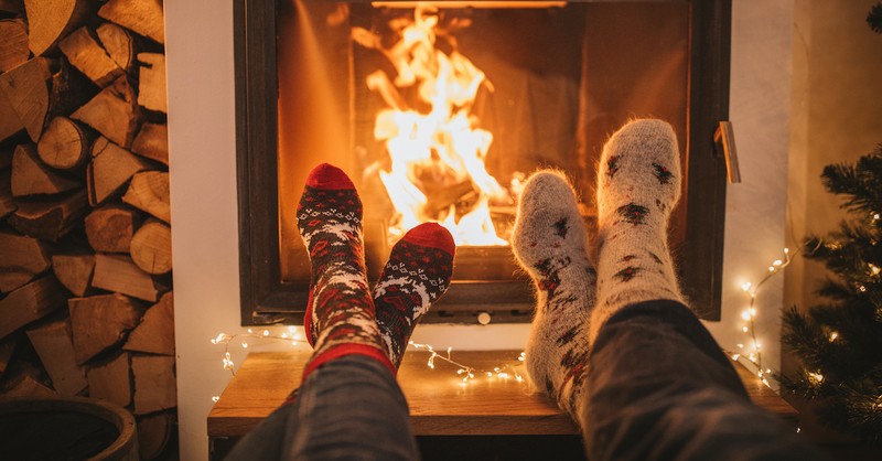 couple's feet by fireplace with cozy socks on