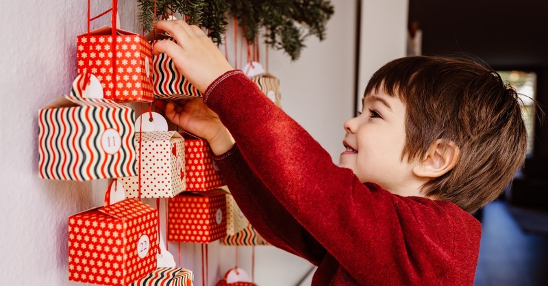 Little boy opening an Advent calendar gift