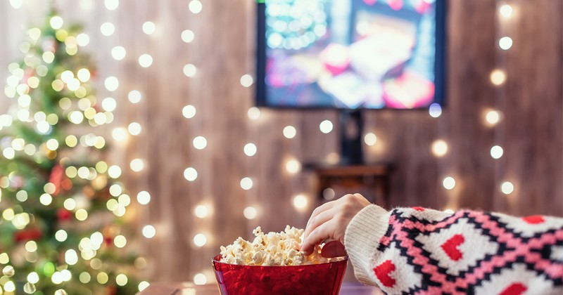 woman watching christmas movie with popcorn