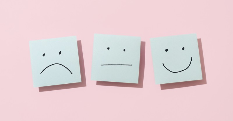 emotion faces on sticky notes on pink background