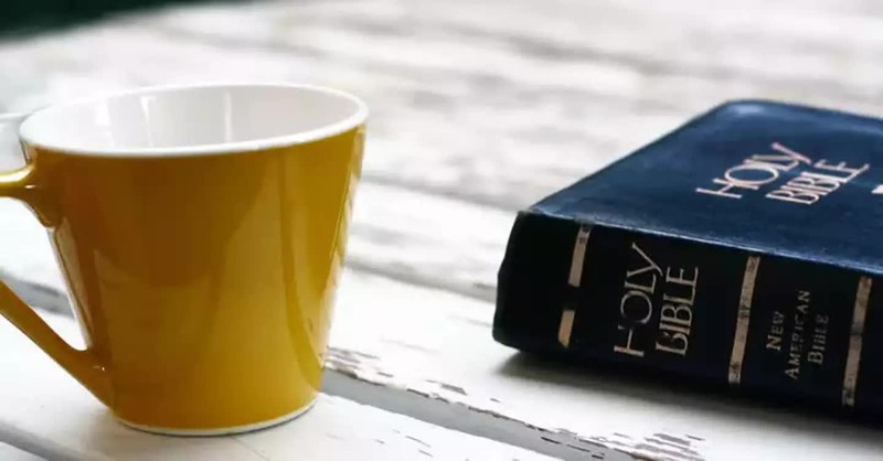 Bible on table with coffee mug