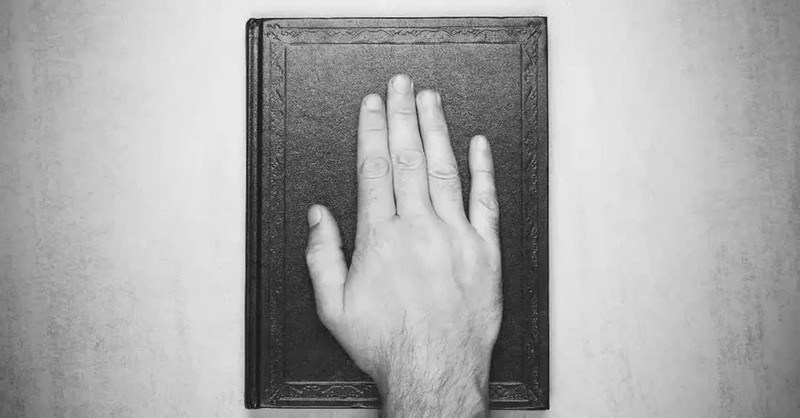 Hand on top of a Bible