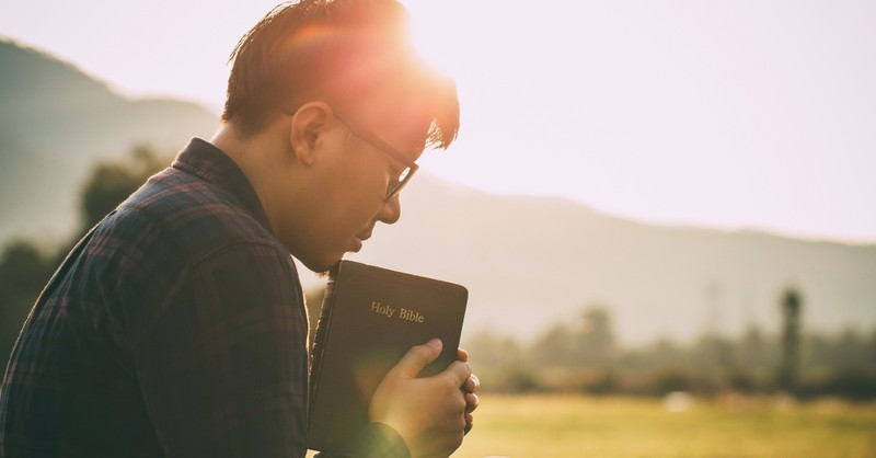 Man praying over the Bible