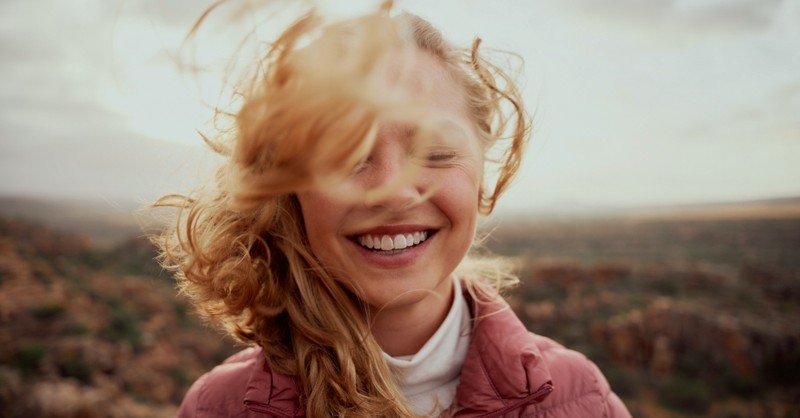 Woman smiling with her hair blowing in the wind