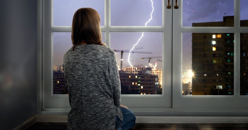 Woman looking out to a stormy sky