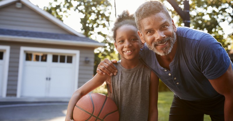 Dad with daughter playing basketball