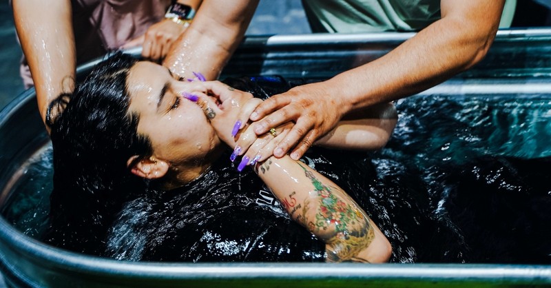 Woman being baptized in a tub