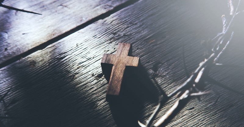 Wooden cross on a table in the middle of the thorn of crowns