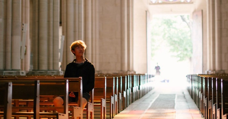 man sitting in pew in empty church