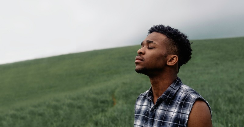 man with eyes closed praying