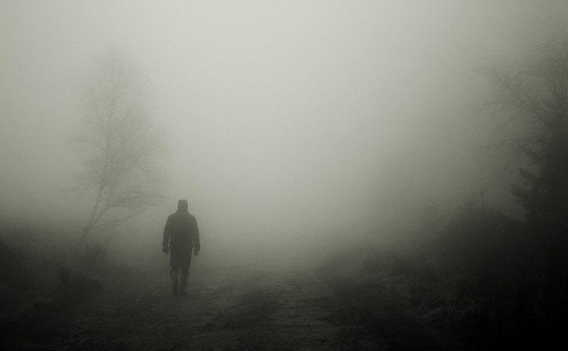 man walking in the fog
