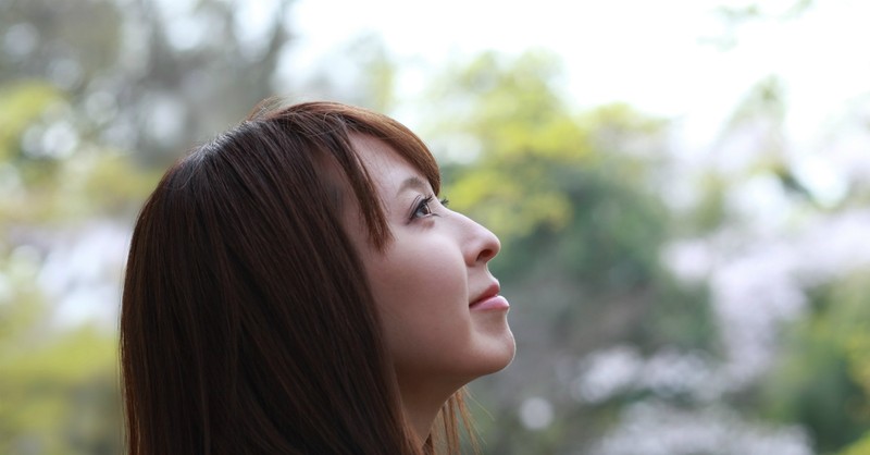 asian woman looking up at the sky, peaceful