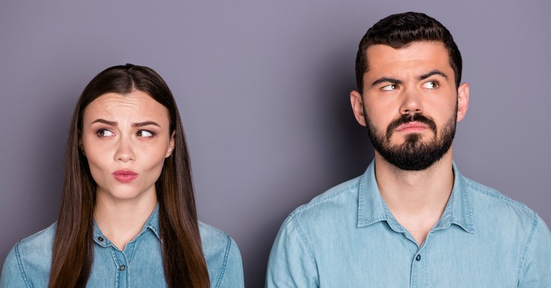 man and woman looking unsure and confused looking away from each other