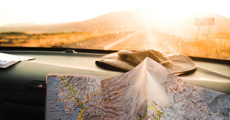 view of road from dashboard of car with map spread out